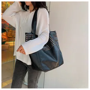 Close-up of stylish black tote bag with silver studs and premium leather texture details