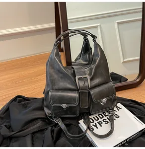 Detail of vintage gray leather backpack with double front pockets and silver metal buckles