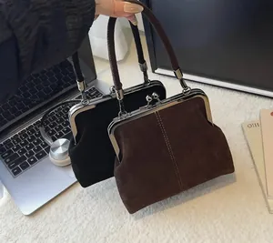 Close-up of vintage frame handbag with spherical metal clasps and matte leather texture