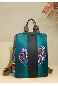Detail of teal nylon backpack with traditional ethnic patterns and brown straps