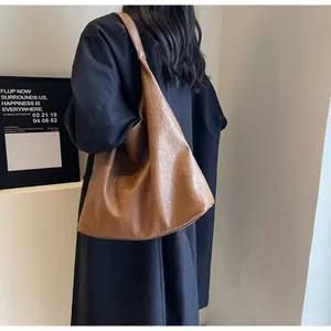 Close-up of vintage brown tote bag featuring natural wrinkled leather texture and wide strap