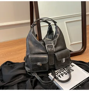 Detail of vintage matte leather tote bag with white stitching and metal buckle design
