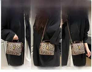 Detailed view of leopard print handbag showing handheld, shoulder and crossbody styles