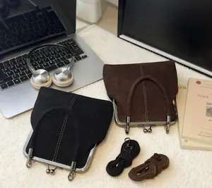Detail of vintage suede doctor bags in black and brown with metal clasp and straps