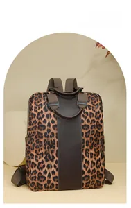 Detail of leopard print nylon backpack showing side pocket and brown leather accents