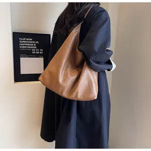 Caramel brown large tote bag in vintage faux leather shown worn on the shoulder