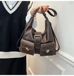 Close-up of retro dark brown PU leather bag with silver turn-lock pockets and wide buckle