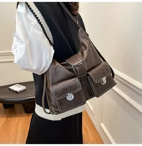 Detail view of vintage dark brown leather shoulder bag with buckle pockets on a model