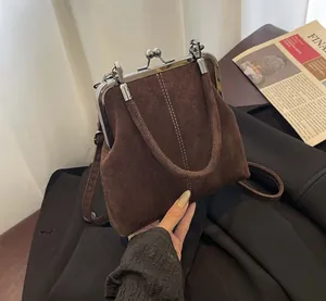 Detail of vintage brown suede clasp bag with silver metal frame and double bead closure