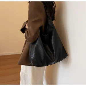 Detail of black textured leather tote bag on shoulder with vintage crushed pattern