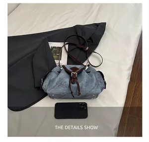 Dettaglio della borsa a secchiello blu con finiture in pelle e rivetti sulla base