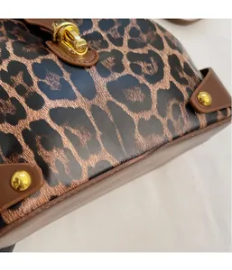 Close-up of leopard print leather texture and premium gold metal twist lock hardware
