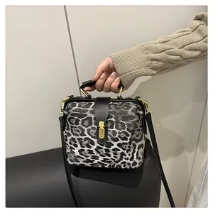 Detail of leopard print handbag with gold metal clasp and premium black leather trim