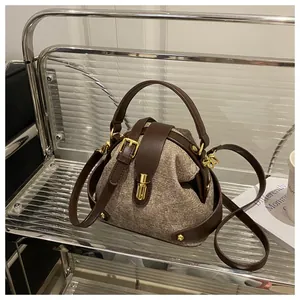 Κοντινή λήψη vintage τσάντας από καφέ tweed με δερμάτινη επένδυση και χρυσό κούμπωμα