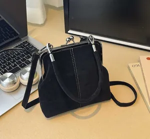 Close-up of retro black suede doctor bag with metallic frame and white contrast stitching