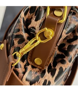 Detailed close-up of leopard print fabric with luxury gold hardware and leather trim