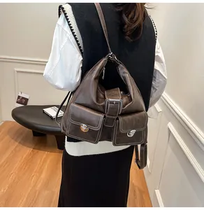 Detailed back view of vintage dark brown leather backpack with metal buckles on model
