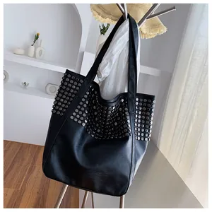 Detailed close-up of a black tote bag featuring stylish silver stud rivet decorations