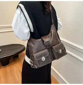 Detail of vintage brown leather tote bag featuring dual front pockets and silver metal locks