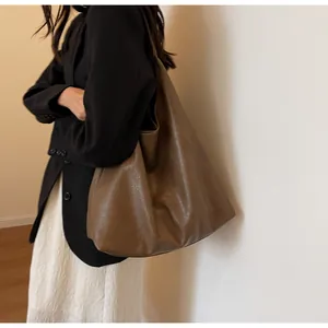 Λεπτομερής πλευρική όψη μεγάλης vintage τσάντας tote που φοριέται από μοντέλο σε στούντιο