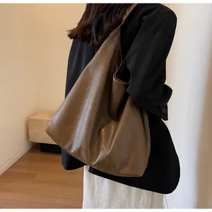 Macro detail of deep brown tote bag with premium leather texture and slouchy hobo design
