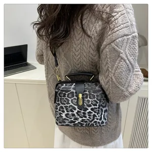 Detail of leopard print doctor bag with vintage metal clasp and black leather handle