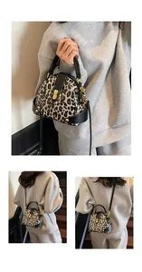 Detail of leopard print shell bag with gold metal twist lock and black leather handle