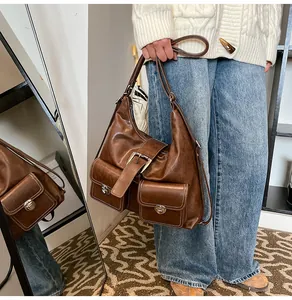 Detail of dark brown vintage faux leather tote with decorative stitching and twin front pockets