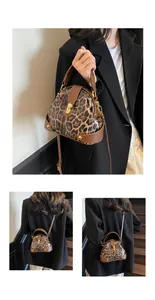Detail of leopard print shell bag with golden twist lock and brown leather trim