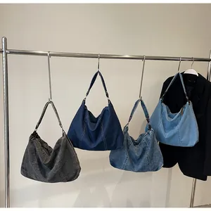 Πολλαπλές αποχρώσεις τσαντών hobo από denim κρεμασμένες σε σειρά για σύγκριση χρωμάτων