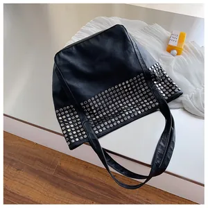 Close-up of black rivet tote bag with silver metal studs and textured lychee grain leather