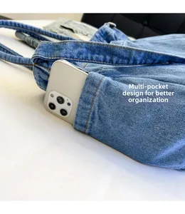 Detail of the side pocket on a light blue denim tote bag for better organization
