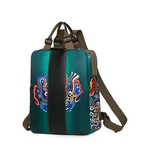 Detail of teal nylon backpack featuring intricate dragon embroidery and brown straps
