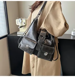 Detail of vintage grey leather tote bag with functional pockets and silver hardware