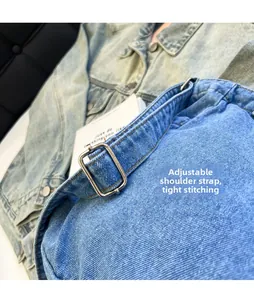 Detailed macro view of adjustable metal buckle and stitching on blue denim tote bag