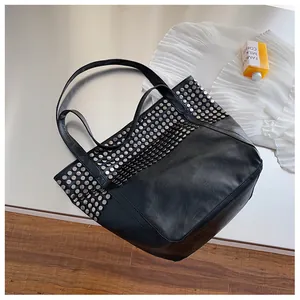 Detailed view of silver stud embellishments on black faux leather tote shopping bag