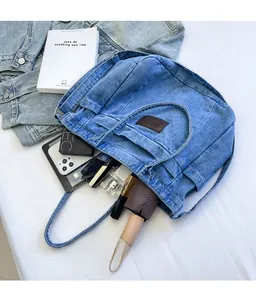 Detailed view of spacious interior of blue denim tote bag holding daily essentials