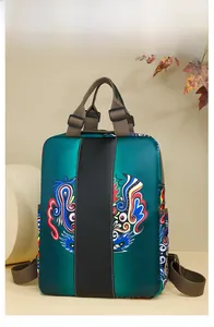 Detail of green nylon backpack showing vibrant lion dance prints and textile straps