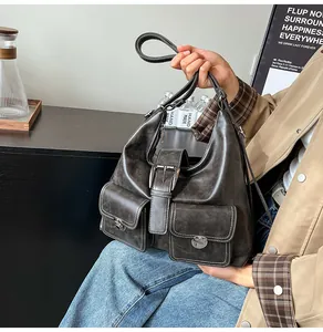 Detail showing multi-pocket design with silver metal buckles and contrast stitching