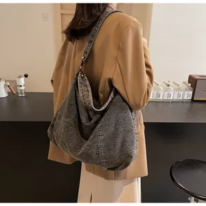 Μεγάλη σκούρα γκρι τσάντα hobo denim με αντίθεση ραφών σε πίσω όψη πάνω στο μοντέλο