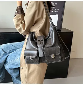 Detail of dark grey Hobo bag with white contrast stitching and silver buckle pockets