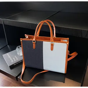 Dettaglio della borsa tote bicolore con tracolle in pelle marrone in esposizione