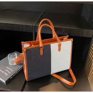 Dettaglio della grande borsa tote patchwork tricolore con manici in pelle arancione