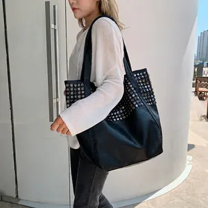 Fashionable black tote bag with silver studs on leather surface for women shoulder wear