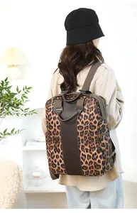 Close-up of leopard print nylon backpack with brown straps worn by a female model