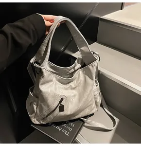 Λεπτομέρεια ανοιχτόγκριζης τσάντας tote με υφή δέρματος PU και μπροστινή τσέπη με φερμουάρ