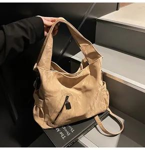 Λεπτομέρεια μπεζ τσάντας tote με ανάγλυφη δερμάτινη υφή και φαρδύ ιμάντα ώμου