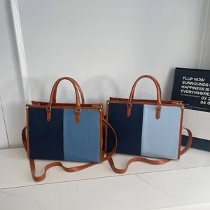 Borsa tote in denim bicolore con manici in pelle e tracolla regolabile alla moda