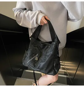 Μαύρη τσάντα tote με ανάγλυφη υφή, πλευρικές τσέπες και ασημένιες λεπτομέρειες φερμουάρ