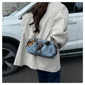 Borsa a secchiello in denim con finiture in pelle marrone e nappa di perline in legno